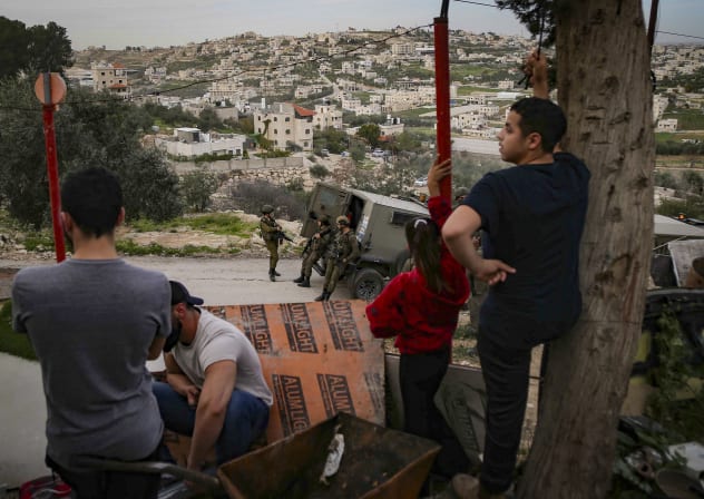 Locals look on as IDF soldiers arrive to destroy a residence in Tarqumiya, west of Hebron, in the West Bank, February 1, 2026; illustrative.