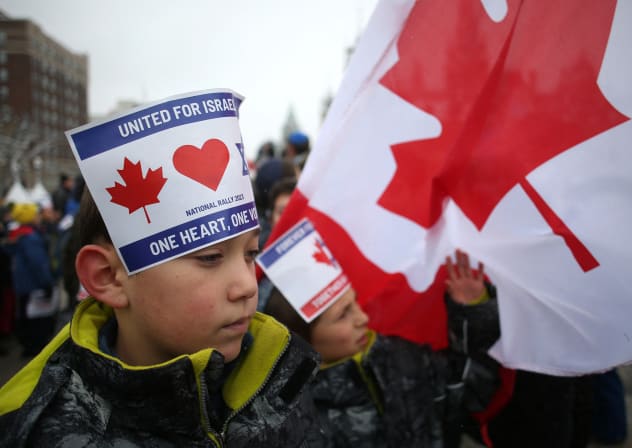 Children wear signs on their heads as they join demonstrators gathering in support of the Jewish community, on Parliament Hill in Ottawa, Ontario, in December 2023. 
