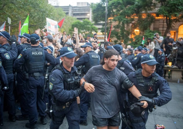 Police officers remove demonstrators gathered at Town Hall Square to protest against President Isaac Herzog's state visit to Australia, in Sydney, Australia, February 9, 2026