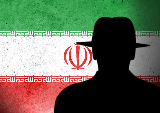 An illustrative silhouette of an intelligence agent handler with a backdrop of the Iranian flag.