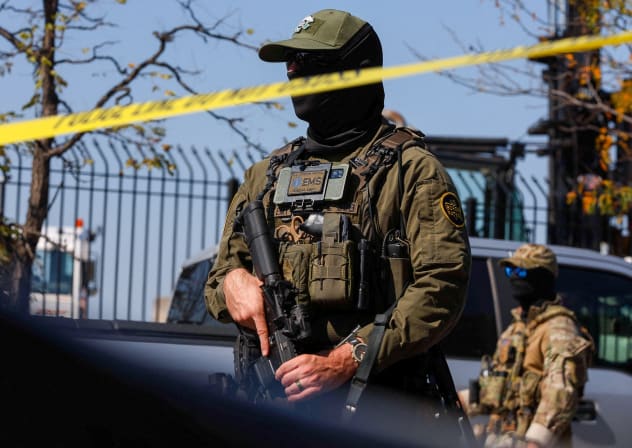 A US Border Patrol officer stands behind tape during demonstrators' standoff with US Immigration and Customs Enforcement (ICE) and federal officers in the Little Village neighborhood of Chicago, Illinois, October 4, 2025.