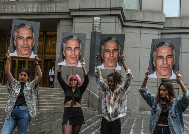 A protest group holds up signs of Jeffrey Epstein in front of the Federal courthouse on July 8, 2019 in New York City.