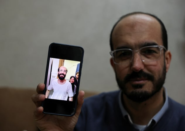 SAMER KHAWEIREH, 45, shows a photo of how he appeared the day he was released from prison four weeks ago after he said he lost 22 kilos of weight in nine months, as he sits in his home in Nablus in the West Bank, February 11, 2026.
