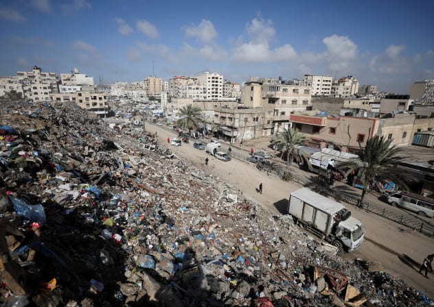 PALESTINIANS WALK near a landfill, in Gaza City, February 11, 2026.