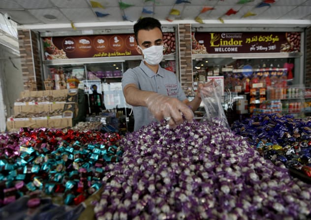 A worker packs sweets outside a shop as Palestinians prepare for the upcoming holiday of Eid al-Fitr marking the end of Ramadan in 2020.