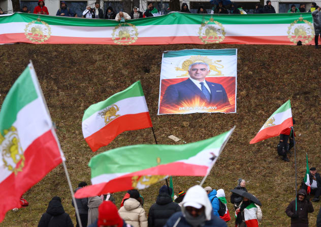 PROTESTERS HOLD ‘Lion and Sun’ pre-Iranian Revolution national flags, near an image of Reza Pahlavi.