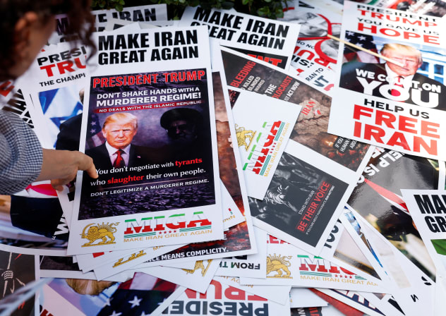 A person picks up a poster from a pile while taking part in a rally in support of Iranian protesters during a global day of action in Los Angeles, California, US, February 14, 2026