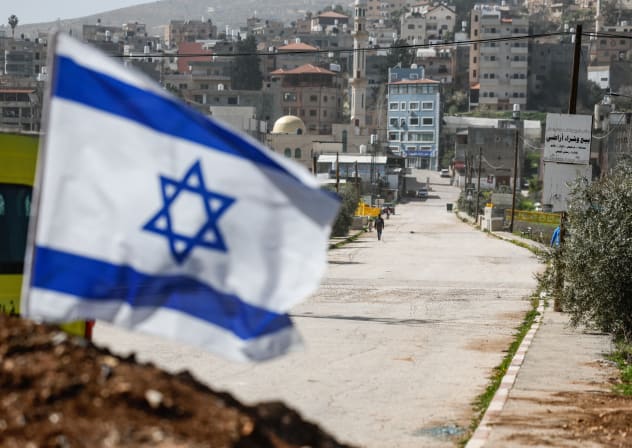 An Israeli flag flutters at a dirt barrier that was recently placed by the Israeli military, at the main entrance to Luban e-Sharkiya, between Nablus and Ramallah, in the West Bank, February 16, 2026