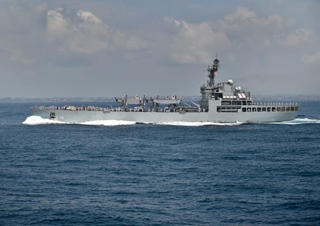 Personnel onboard the Indian Navy's INS Shardul salute during the opening ceremony of the 5th Multilateral Naval Exercise Komodo 2025 off the coast of Indonesia's resort island of Bali on February 16, 2025.