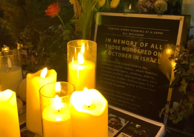 A photograph taken on January 18, 2025 shows lit candles and a placard displayed during a vigil in the centre of Brighton, England, for people held hostage by Hamas in Gaza.