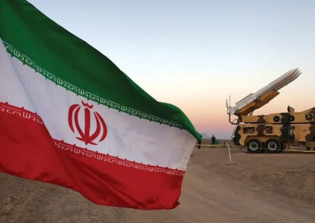 Una bandera iraní aparece cerca de un misil durante un ejercicio militar, con la participación de unidades de defensa aérea de Irán en octubre. 