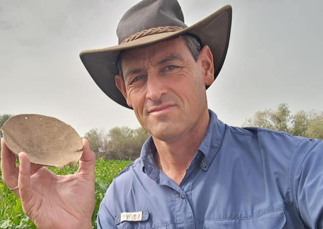 Archaeologist Achiya Cohen-Tavor holding bronze scale pan found in the ancient Jewish settlement of Sussiya, February 19, 2026.
