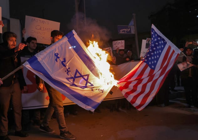 Basij paramilitary members burn Israeli and US flags outside the British Embassy in Tehran, January 14, 2026; illustrative.