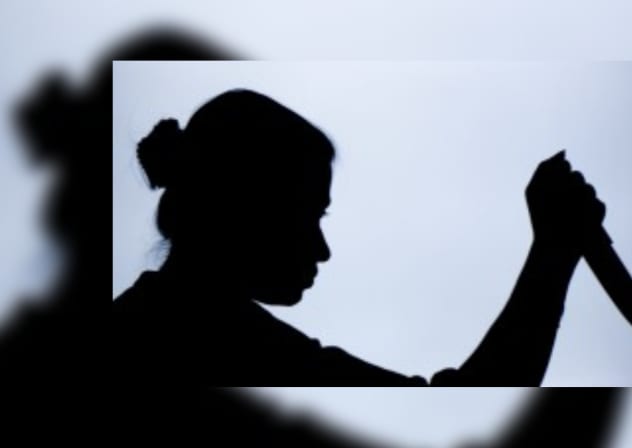 A silhouette of a woman about to stab someone; illustrative.