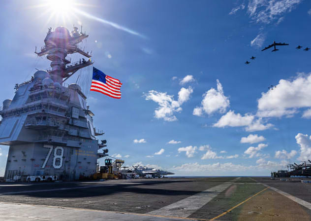 In this handout provided by the U.S. Navy, USS Gerald R. Ford (CVN 78), F/A-18E/F Super Hornets assigned to Strike Fighter Squadrons 31, 37, 87, and 213 from embarked Carrier Air Wing Eight, and a U.S. Air Force B-52 Stratofortress operate as a joint, multi-domain force, November 13, 2025. 