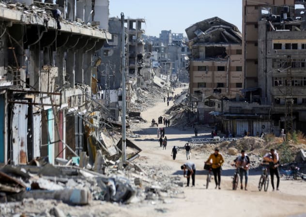 Palestinians make their way in a devasted neighborhood, amid the ongoing Israel-Hamas conflict, in Gaza City, October 24, 2024.