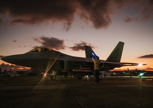 In this handout photo from the US Air Force, a US Air Force crew chief guides in an F-22 Raptor following a large-scale strike against Venezuela military targets in support of Operation Absolute Resolve, in Ceiba, Puerto Rico, January 3, 2026.