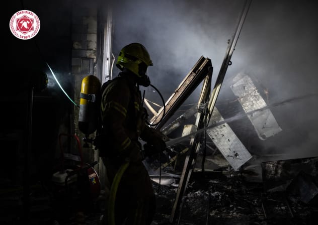 A firefighter works at the scene in central Israel on march 1, 2026. 