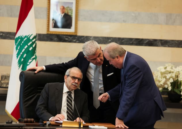 Lebanese Prime Minister Nawaf Salam speaks with Finance Minister Yassine Jaber and Lebanese Industry Minister Joe Issa el-Khoury during a cabinet meeting in Beirut, Lebanon, December 23, 2025.