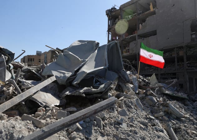The national flag of Iran flies in the wind as debris lies scattered in the aftermath of an Israeli and US strike on a police station, in Tehran, Iran, March 3, 2026