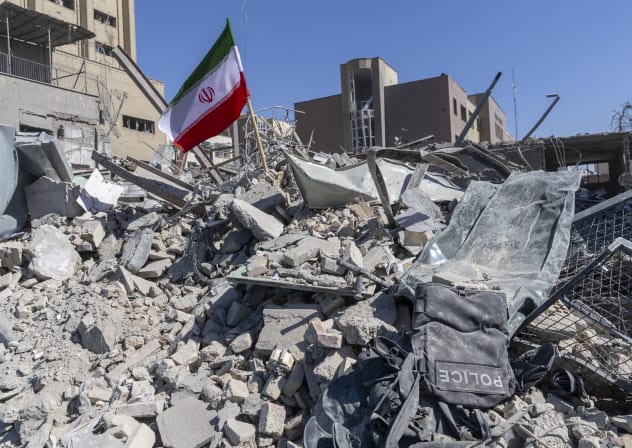 An Iranian flag is planted in the rubble of a police station, damaged in airstrikes yesterday, on March 3, 2026 in Tehran, Iran.