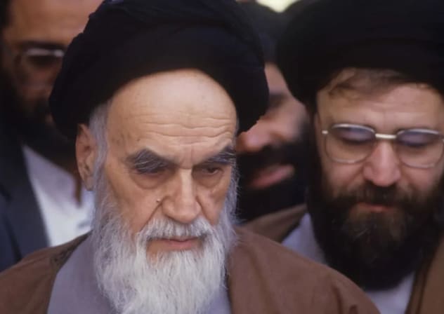 Ruhollah Jomeini (izquierda), líder y fundador de la República Islámica de Irán, con aspecto frágil, vota en las elecciones parlamentarias en su residencia de Jamaran, al norte de Teherán, el 8 de abril de 1988. 