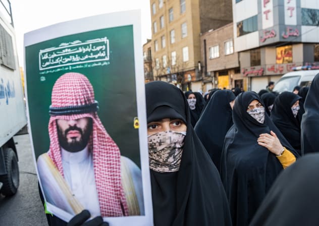 Masked Basiji woman carries a photo of Mohammed bin Salman during a parade of an alleged 110,000 paramilitary Basij and IRGC forces in downtown Tehran, Iran, January 10, 2025