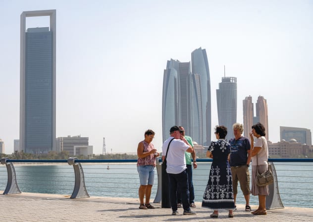 TOURISTS STAND near Etihad Towers in Abu Dhabi last week shortly after an Iranian missile attack.