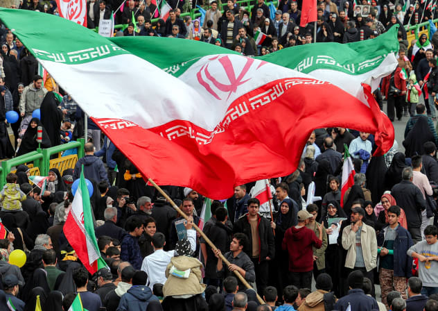 A man waves a giant Iranian flag during a rally marking the 47th anniversary of the 1979 Islamic revolution in Tehran on February 11, 2026. 