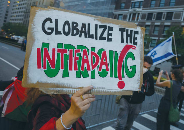 A PRO-PALESTINIAN protester holds a ‘Globalize the intifada’ sign near during an Anti-Israel protest in New York City, last year. The phrase is a call to expand the violence that killed thousands of Israelis in two terrorist uprisings and extend it worldwide against global Jewry, the writer says.