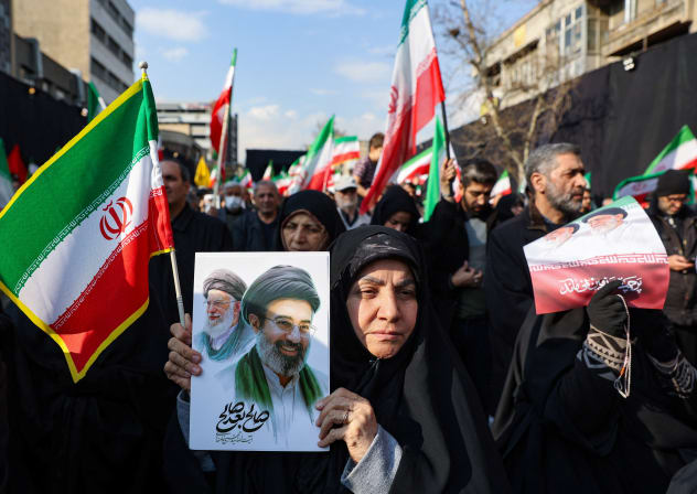 A woman holds a placard with an image of Iran's new supreme leader Mojtaba Khamenei alongside late supreme leader Ayatollah Ali Khamenei, on the day of a gathering to support Mojtaba Khamenei, amid the US-Israeli conflict with Iran, in Tehran, Iran, March 9, 2026.