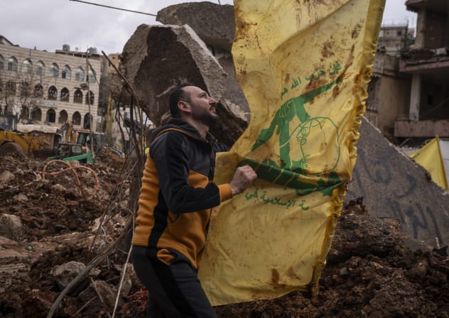 A man places a Hezbollah flag in the ground on March 7, 2026 in Nabi Chit, Lebanon.