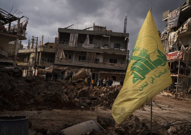 A Hezbollah flag is seen in front of destroyed buildings from a previous airstrike on March 7, 2026 in Nabi Chit, Lebanon.