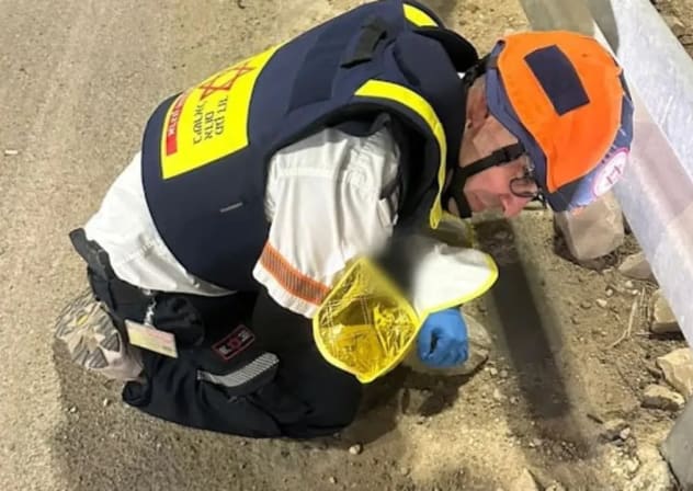 El paramédico de Magen David Adom, Elad Pas, protege a un bebé recién nacido durante una alerta de misil.