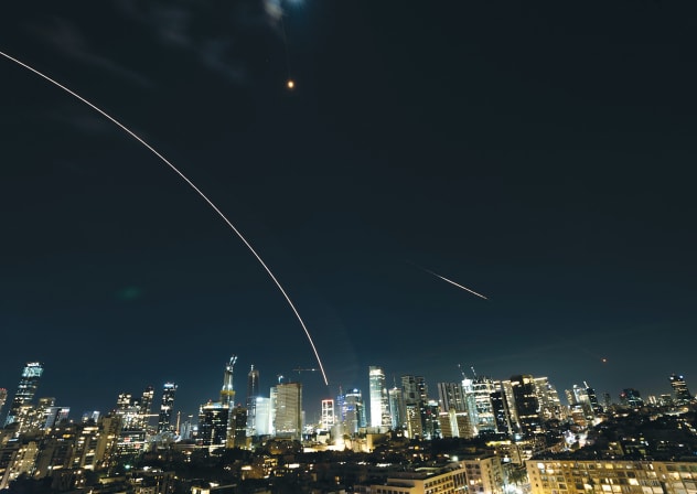 TWO WEEKS under fire: Missile trails arc across the night sky above Tel Aviv. Israel has endured days of attacks that have repeatedly sent civilians rushing to bomb shelters.