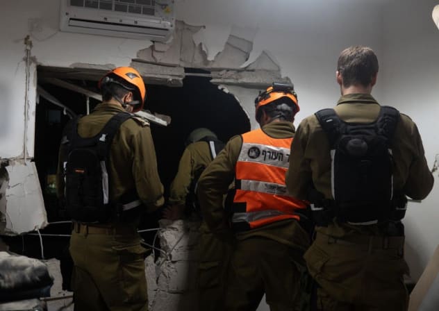 IDF Home Front Command soldiers at the scene of shrapnel hitting a building in central Israel, March 15, 2026.