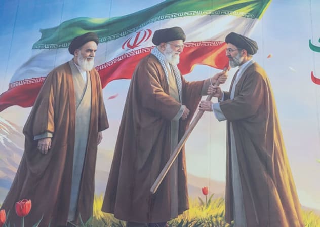 Aquí, un gran cartel muestra (de izquierda a derecha) al primer líder de la Revolución Islámica, Ruhollah Jomeini; al segundo líder, Alí Jamenei; y, a la derecha, al nuevo líder de la revolución, Mojtaba Jamenei. 