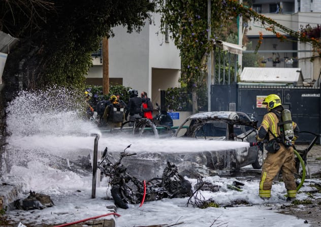 Israel security rescue forces inspect the damage at the scene where a missile fired from Iran toward Israel caused damage in central Israel, March 15, 2026. 