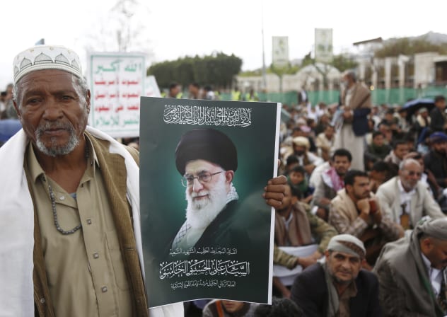 A Yemeni man holds a posters depicting the former Iranian Supreme Leader Ali Hosseini Khamenei during a rally by Houthi supporters on International Quds Day on March 13, 2026 in Sana'a, Yemen.