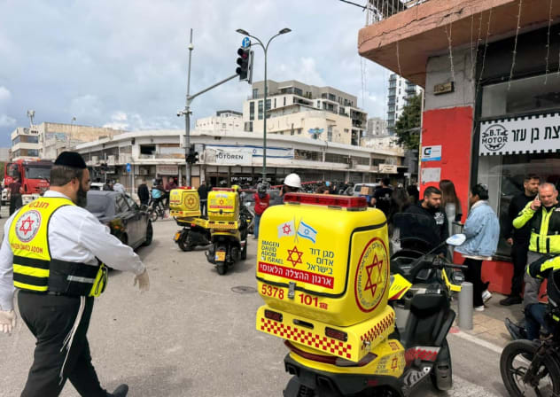 Magen David Adom paramedics at the scene following shrapnel from an Iranian missile hitting in the Tel Aviv area, March 26, 2026.