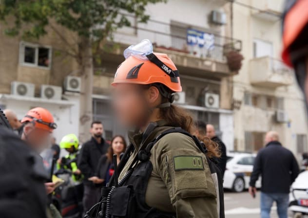 An IDF Home Front Command officer inspects damage following an Iranian missile launch towards Israel, March 26, 2026.