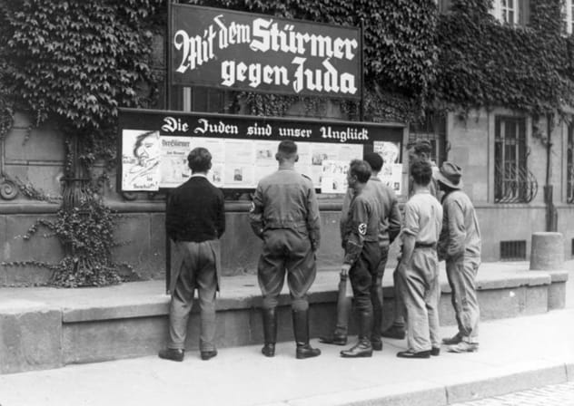 Germans read an antisemitic tabloid on a billboard: 'The Jews are our misfortune.' That was in 1935. The Palestinian Authority still teaches hate and violence toward Jews today, the author writes.