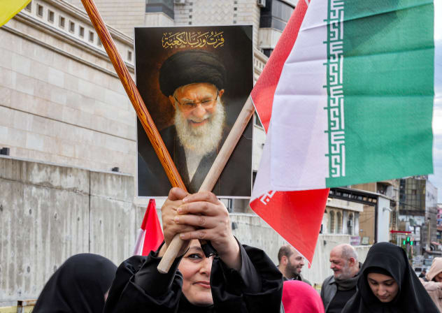 A woman holds a sign depicting Iran's late supreme leader Ali Khamenei during a rally organised by Lebanese political parties supporting the Hezbollah movement outside the Iranian embassy in Beirut on March 26, 2026.