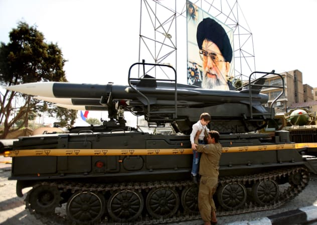 A SOLDIER from Iran's revolutionary guard helps a child sit on a military display in Baharestan Square to commemorate the 1980-88 Iran-Iraq war during "sacred defence week" in southern Tehran September 23, 2006.