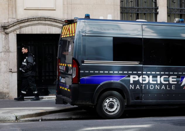 A private security member stands next to a police van outside Bank of America’s Paris offices, after French anti-terrorism prosecutors opened an investigation into attempted destruction by fire or other dangerous means in Paris, France, March 30, 2026. 