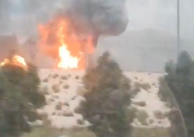 Smoke and flames rise from the South Pars gas field following an Israeli strike, as seen through the window of a moving vehicle, amid the US-Israeli conflict with Iran, in Asaluyeh, Bushehr Province, Iran, March 18, 2026, in this screen grab obtained from social media video. 