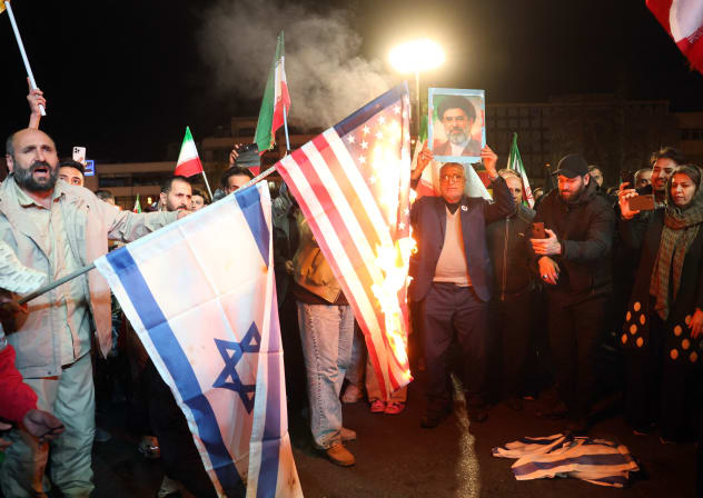 Iranians burn US and Israeli flags as react after the ceasefire announcement at the Enqelab square, in Tehran, on April 8, 2026.