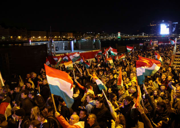 Supporters of Peter Magyar, leader of the opposition Tisza party, hold up Hungarian flags, after the announcement of partial results of the parliamentary election, in Budapest, Hungary, April 12, 2026.