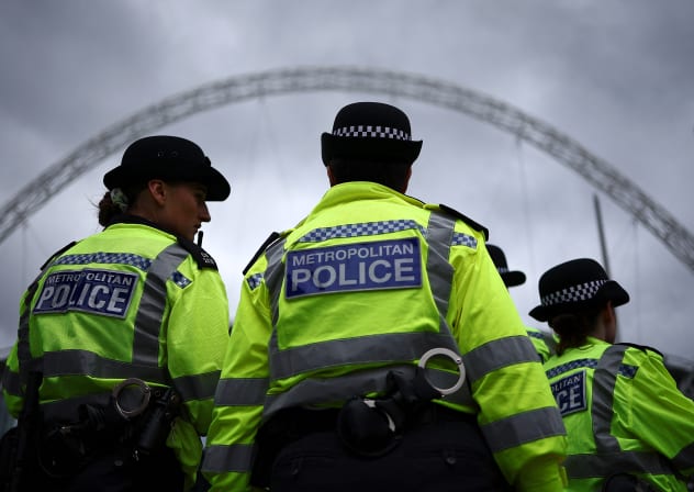 Metropolitan Police officers stand on duty as fans of US mega-star Taylor Swift, so-called "Swifties", as arrive at Wembley Stadium in London on August 15, 2024, ahead of the first of five concerts she is playing at the stadium.