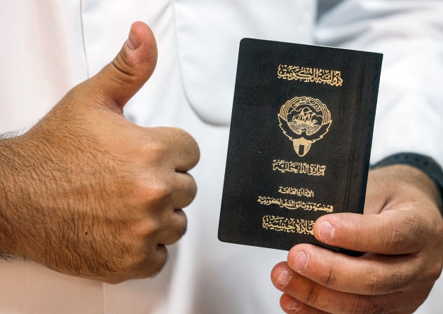  A voter holds his proof of Kuwaiti citizenship upon arriving at a polling station during parliamentary elections in Kuwait City on June 6, 2023.